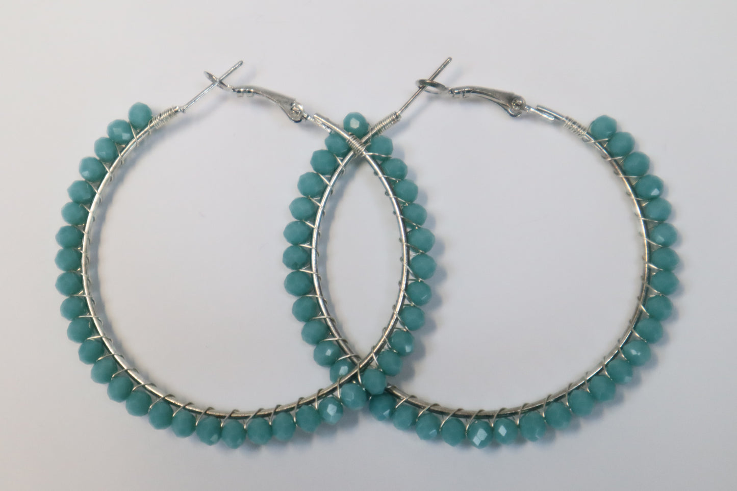 Pair of silver hoop earrings with light blue beads around the outside