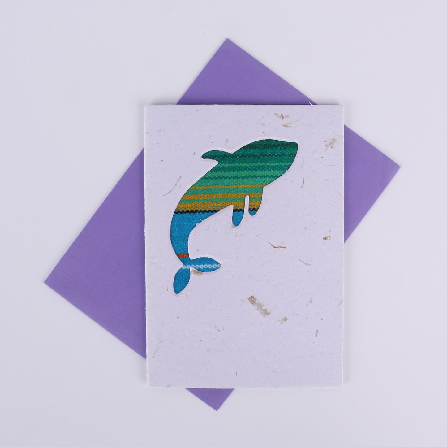 Colourful patterned whale cutout on a white card with a purple envelope underneath