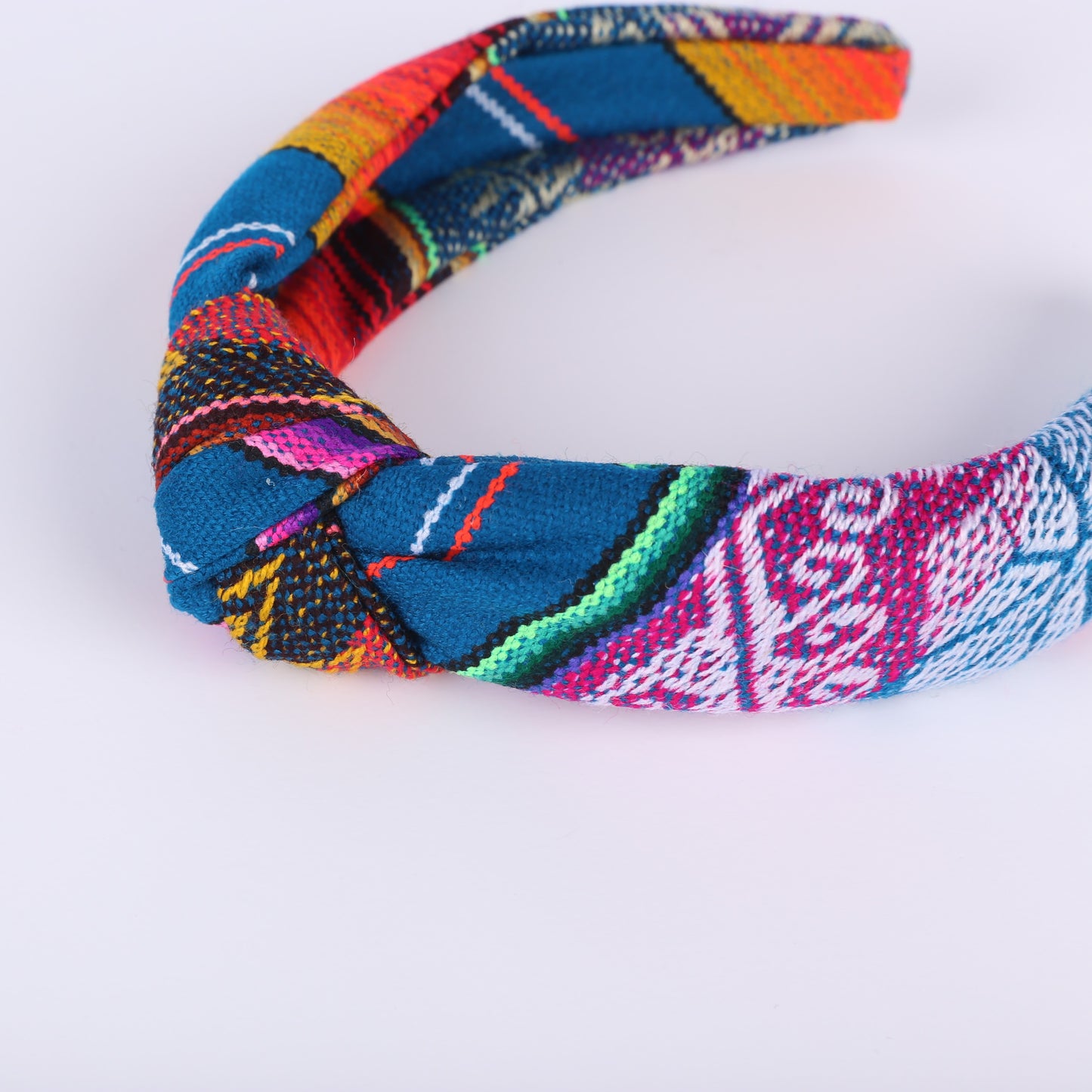 Colourful teal and patterned headband on a white background