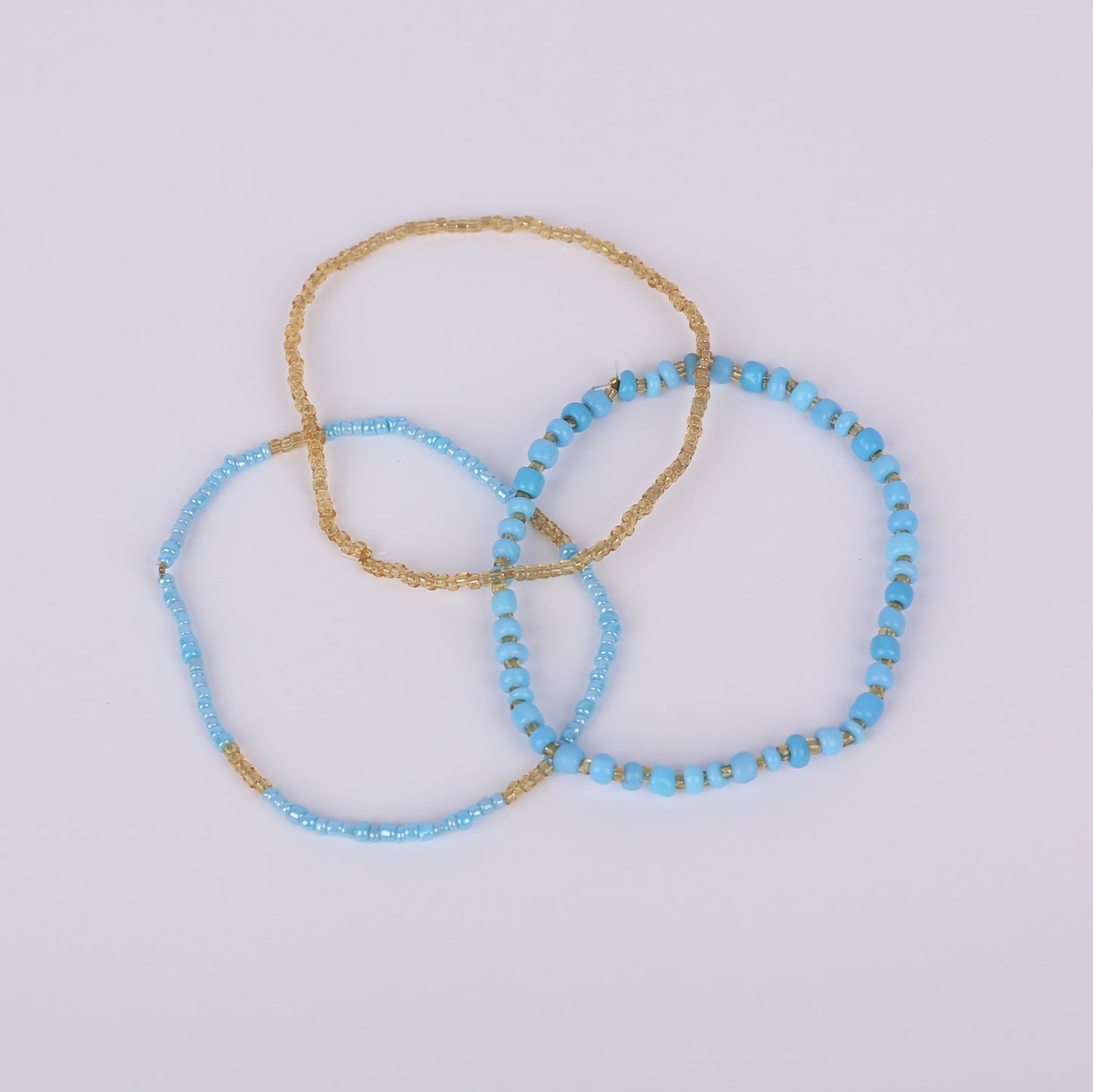 One gold and two blue and gold beaded bracelets