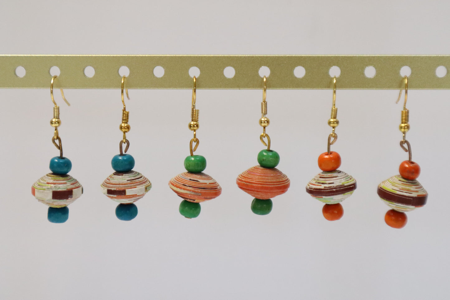 Set of six colourful wooden and paper beaded earrings on a white background