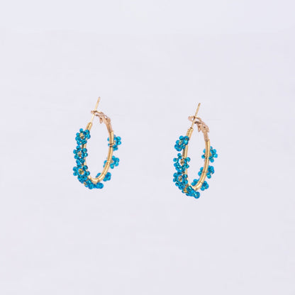 Pair of gold hoop earrings with blue beaded flowers around the edge