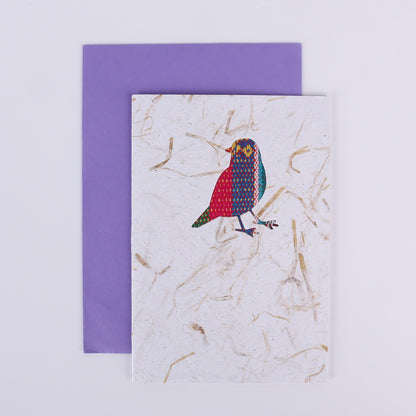 Colourful patterned bird cutout on a white card with a purple envelope underneath