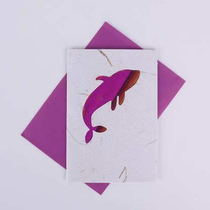 Colourful patterned whale cutout on a white card with a purple envelope underneath