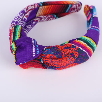 Colourful purple and patterned headband on a white background