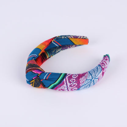 Colourful teal and patterned headband on a white background