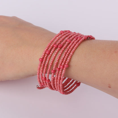 Coral coloured beaded spiral bracelet on a wrist