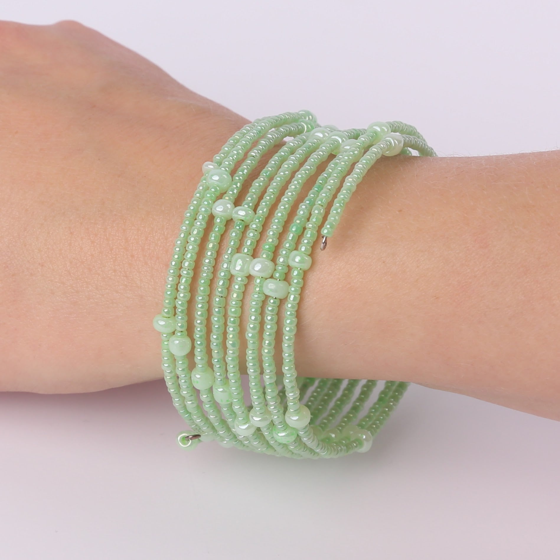 Green beaded spiral bracelet on a wrist