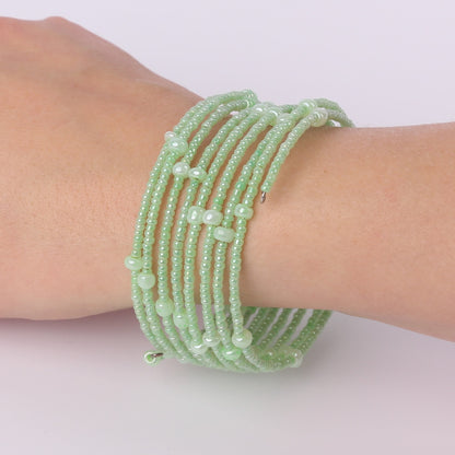 Green beaded spiral bracelet on a wrist