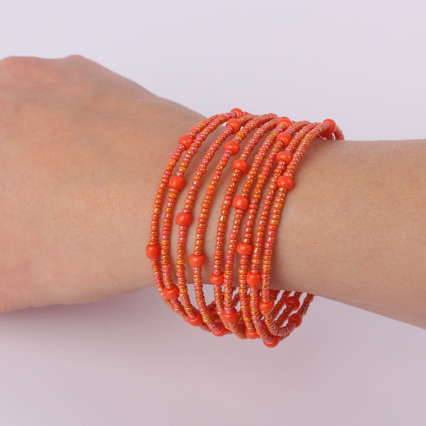 Orange beaded spiral bracelet on a wrist