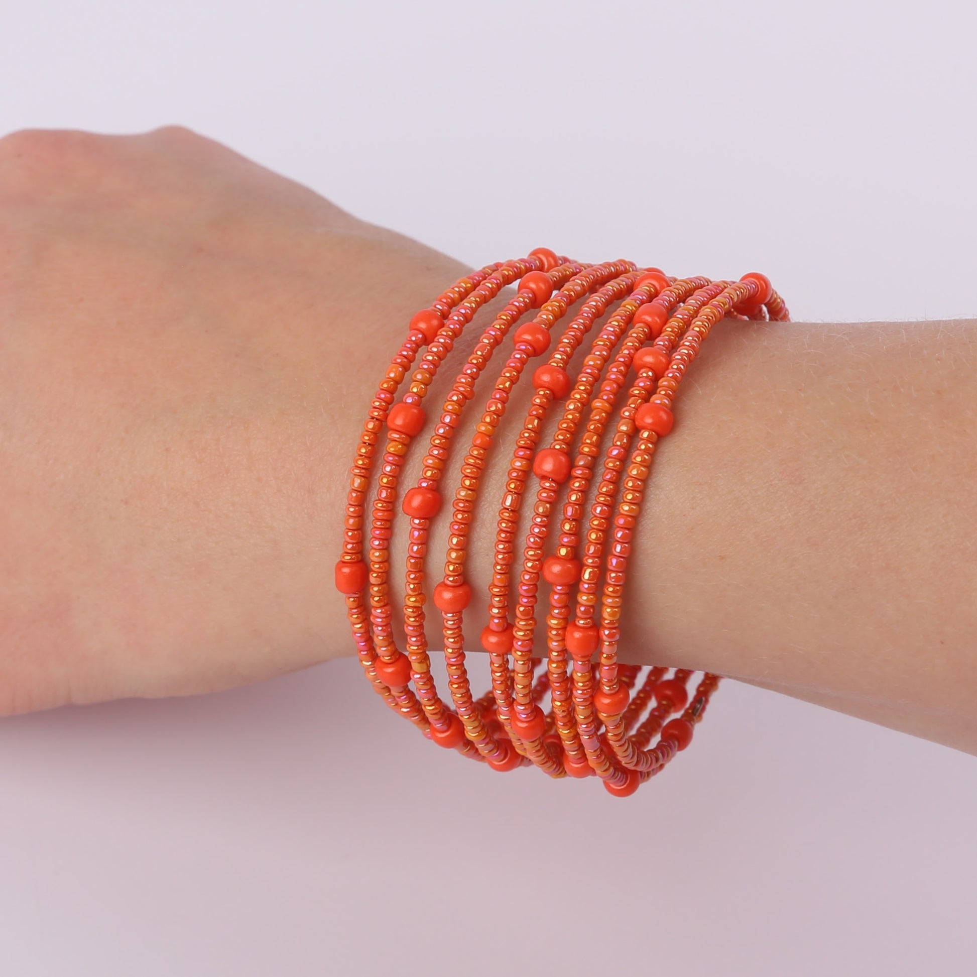 Orange beaded spiral bracelet on a wrist