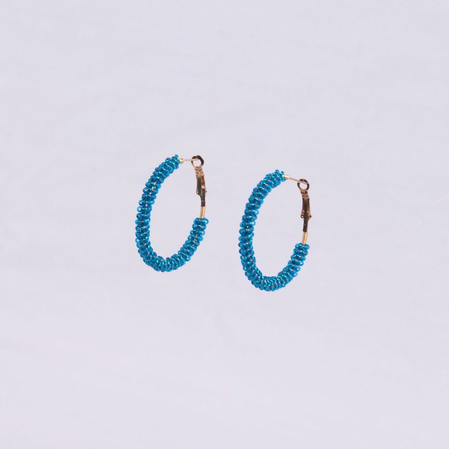 Pair of hoop earrings with blue beads around the hoop