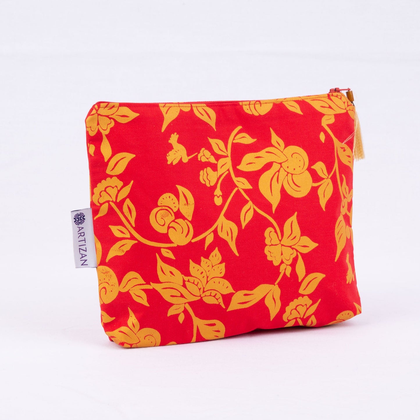 Red and gold floral-patterned pouch with a an Artizan label and a gold tassel. 